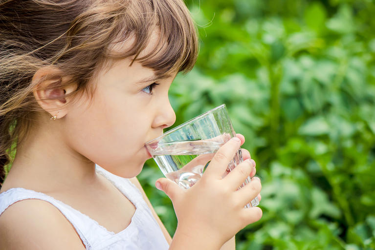 Girl drinking water from a glass. 